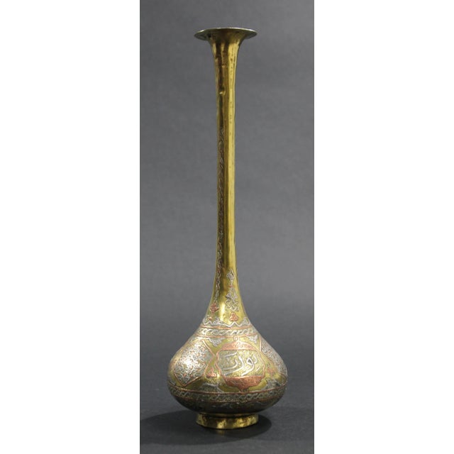 An exceptionally decorative late 19th-century Islamic brass vase, distinguished by its elegant elongated silhouette,...