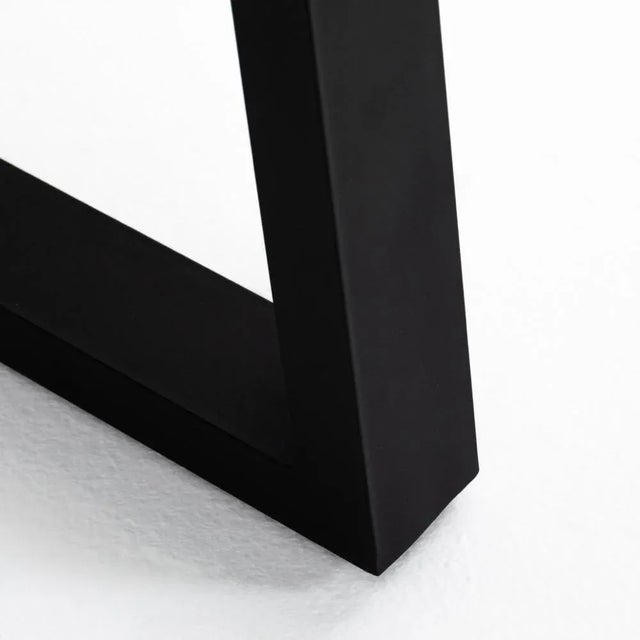 A strikingly simple poly-resin top derived from river sand is polished to a smooth sheen, while an angular black iron base...