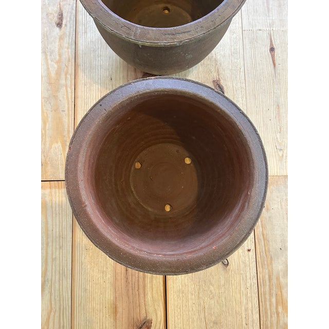 Early 20th century hand thrown rimmed terra cotta planters. Deep rich patina.