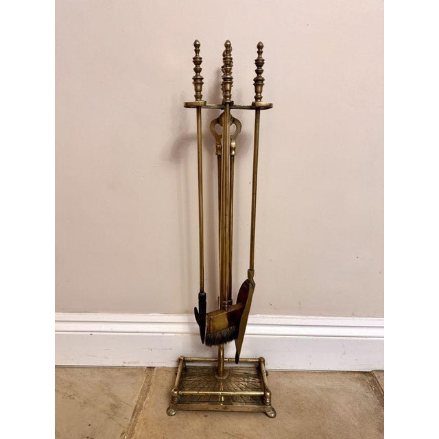 Quality antique Edwardian brass companion set and stand, having a quality antique Edwardian brass stand with a pair of...