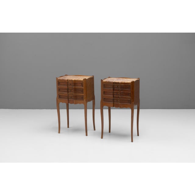 Pair of French mahogany bedside tables with serpentine fronted drawers and rose marble tops. France circa 1930.