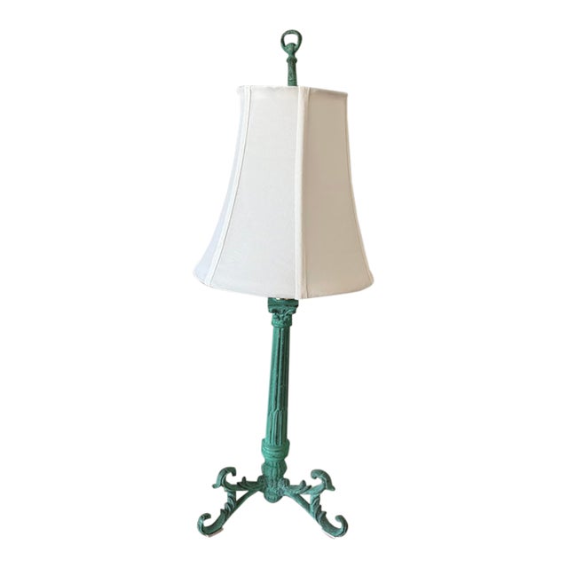 Decorative table lamp featuring an aged patina of verdigris-green finish, sculptural three-footed neoclassical base,...