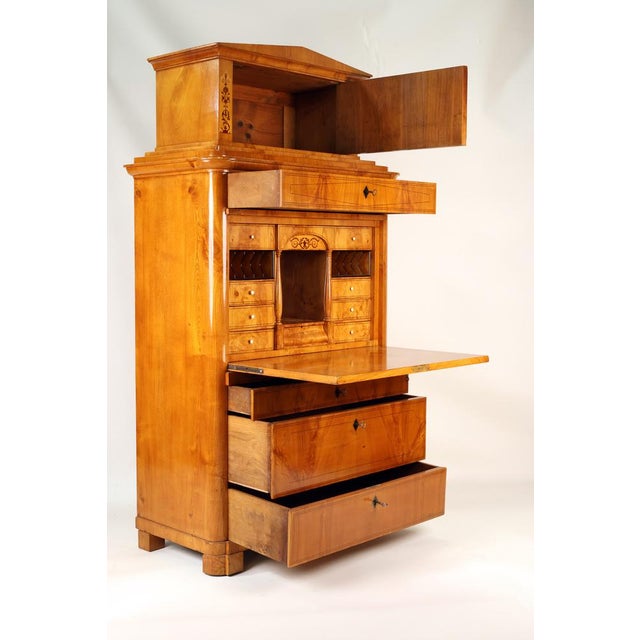 Very elegant top section with pediment, lockable with key, inlaid pilaster strips, drawer underneath, followed by cabinet...