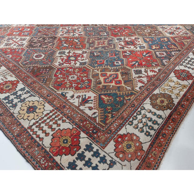 A late 19th century Persian Bakhtiari antique carpet with a bold pattern overall of stepped serrated-edged medallions in...