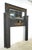 Victorian style fireplace mantel made of black painted wood and gold painted raised ribbon carvings. It features a...