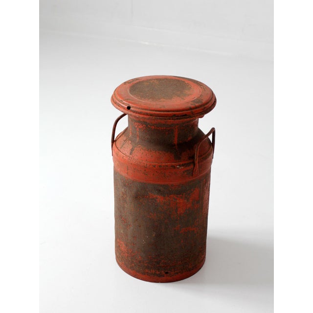 A vintage mid century milk can with a weathered red painted finish and naturally aged patina throughout. The classic dairy...