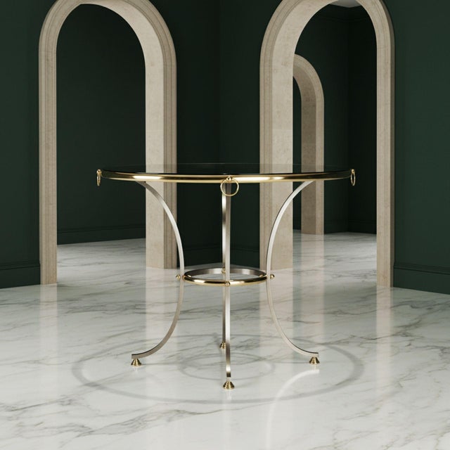 HOLLYWOOD REGENCY POLISHED BRASS AND BRUSHED STEEL CIRCULAR TABLE In the manner of Maison Jansen, circa 1970s 37" diameter...