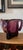 A striking vintage amethyst art glass vase featuring a bold sculptural silhouette with gracefully folded ribbon-like...