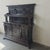 This antique cabinet features intricate hand-carved detailing throughout, elegant columns, and decorative panels. Made...