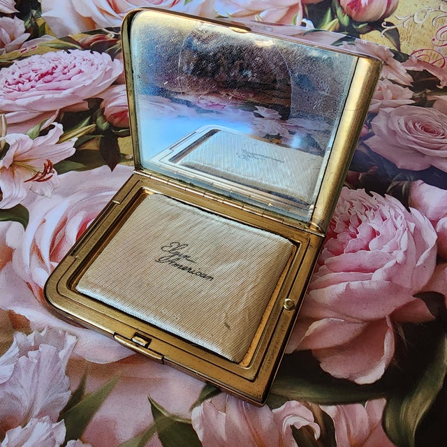 This is an original 1940s Elgin American brass compact with mirror, powder well, and the original Style 1333 powder puff....