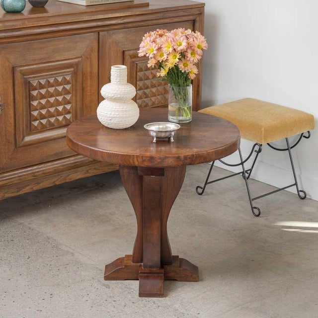 Lovely wood side table from France, 1940s. Thick circular top rests on a curved tapered base with four feet. Original...