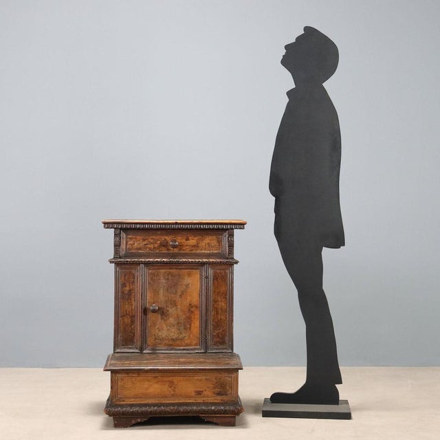 Baroque walnut kneeler. Drawer underneath, central door, and kneeler top that folds open, concealing a storage space...