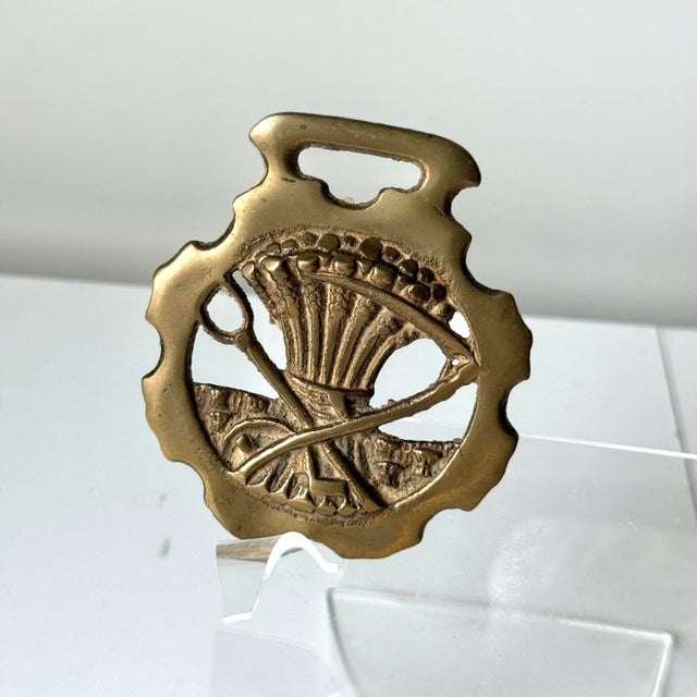 Vintage brass medallion bottle opener in a heavy cast brass. The design features a wheat sheath and sword design.