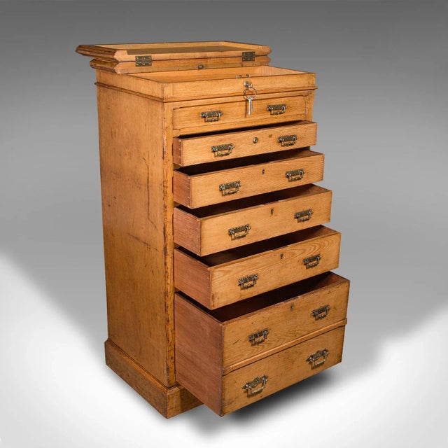 This is an antique banker's chest of drawers. An English, oak tallboy in Aesthetic Period taste by Maple & Co, dating to...