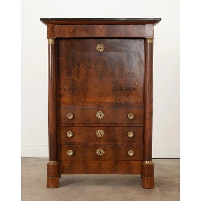 A handsome 19th century Empire secrétaire à abattant made of rich bookmatched and figured walnut. This desk has a black...