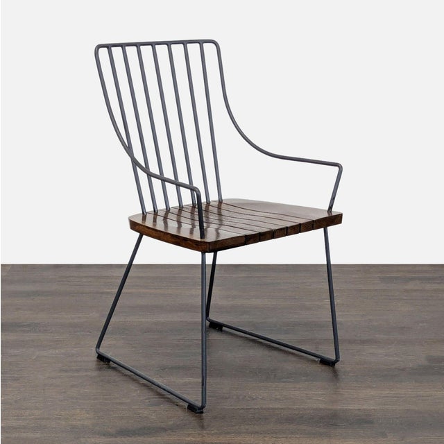 This Crate & Barrel chair features a sturdy black metal frame with a slatted dark wood seat. Its modern, open-back design...