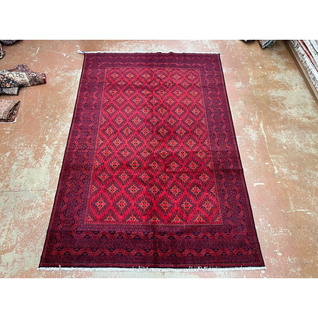 Afghan Turkmen Waziri rug, hand knotted in Afghanistan from 100% wool. Measuring 6’4” x 9’9”, this rug features a vibrant...