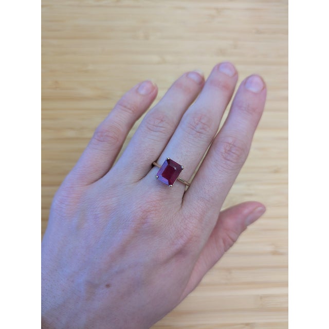 This elegant ring features a 14K yellow gold band and showcases a striking Madagascar ruby weighing 4.81 carats. The ruby...