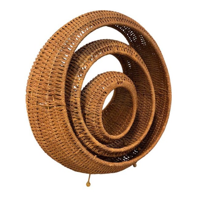 A striking set of three vintage woven rattan baskets featuring a rare concentric circular design and sculptural...