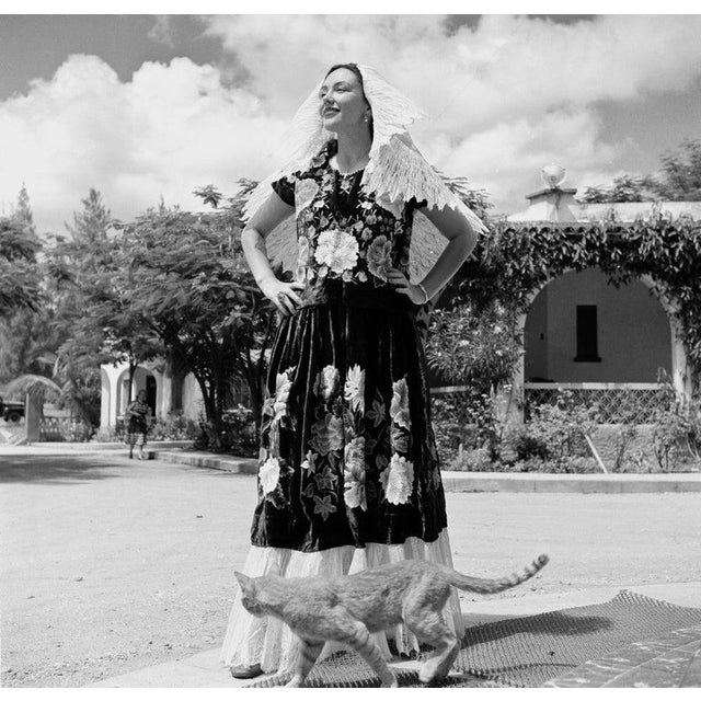 Tuxtla Gutierrez, Mexico TUXTLA GUTIERREZ, MEXICO - JULY 1952: A women dressed in native dress poses on a street with a...