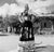 Tuxtla Gutierrez, Mexico TUXTLA GUTIERREZ, MEXICO - JULY 1952: A women dressed in native dress poses on a street with a...