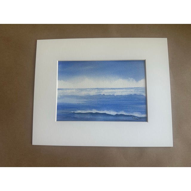 A serene study of sea and sky, this original watercolor celebrates the quiet beauty of rolling waves beneath an expansive...