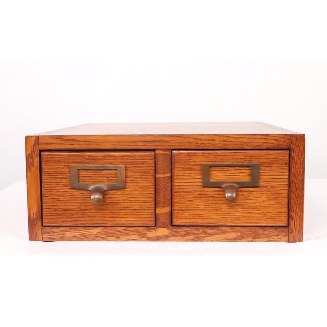 This antique quarter sawn oak card file cabinet is a classic example of early 20th century library or office furniture. It...