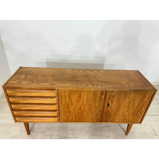 Very beautiful vintage sideboard from the Hellerau 602 series in good condition. The sideboard features five drawers on...