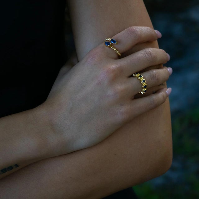 Embrace elegance and wisdom with the Sapphire Teardrop Glow Gold Adjustable Ring. Designed with two radiant teardrop-cut...