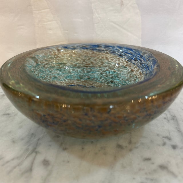 Gorgeous handblown thick glass bowl from Murano, Italy. It has swirls of blues and greens and is filled with copper...