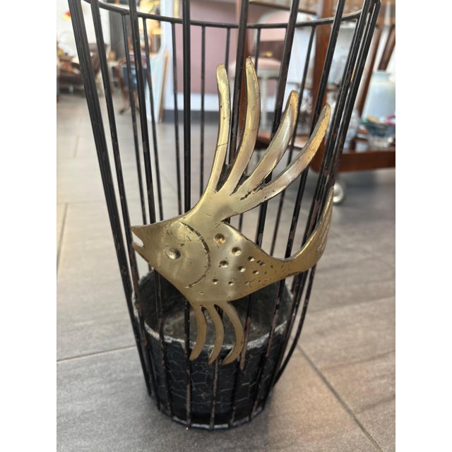 Black umbrella stand by Walter Bosse, 1950s Painted iron rods with drip tray and an appliquéd brass fish, height approx....