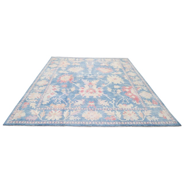 Hand-knotted Oushak with care using traditional rug-making techniques, this wool rug blends timeless craftsmanship with a...