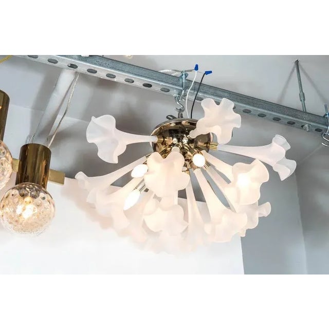 A Mid-Century Modernist flush mount chandelier featuring 15 handblown frosted glass flowers with elongated stems, which...