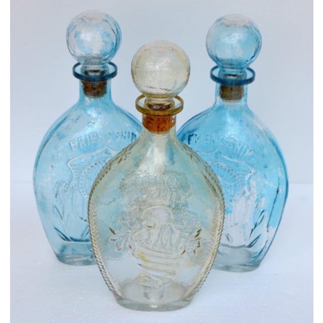 These 3 bottles are vintage blown glass flasks featuring the '2 aqua blue Friendship and amber color Horn of Plenty'...