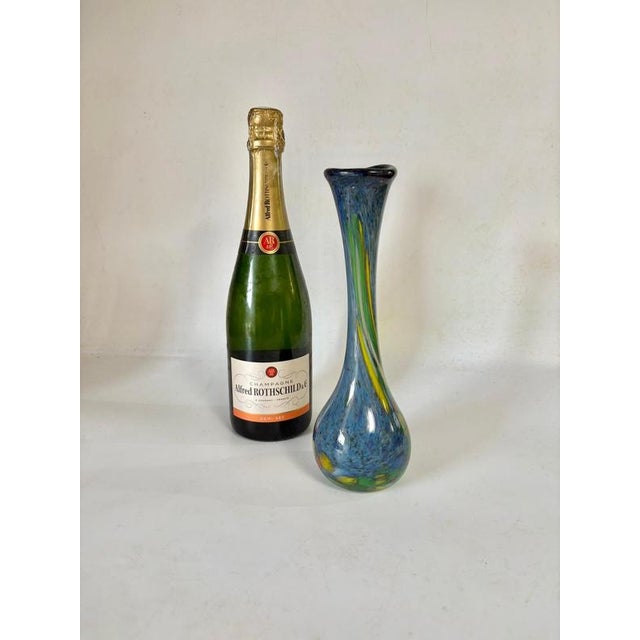 Italian blown glass vase with a slender silhouette and flared neck, crafted from deep blue mottled glass enlivened with...