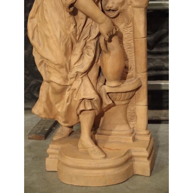 This well detailed terra cotta statue of a woman filling a water jug is from the late 19th century and measures over 30...