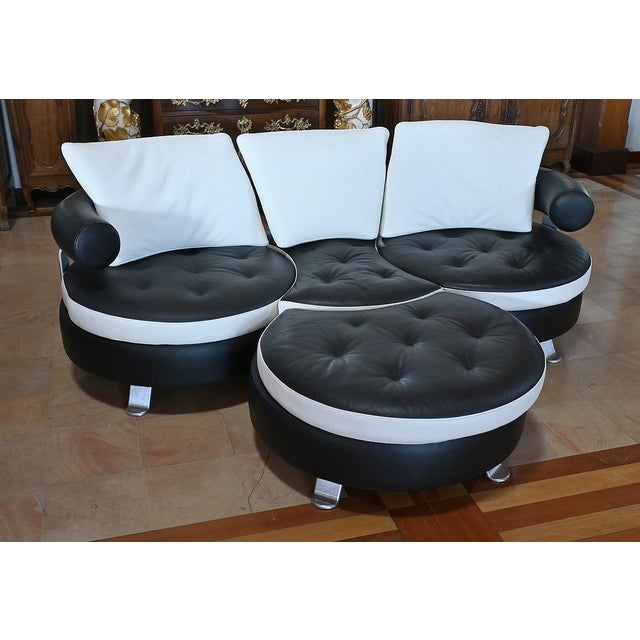 Immerse yourself in the distinctive aesthetic of the 80s with this three-seater sofa, complete with its matching ottoman....