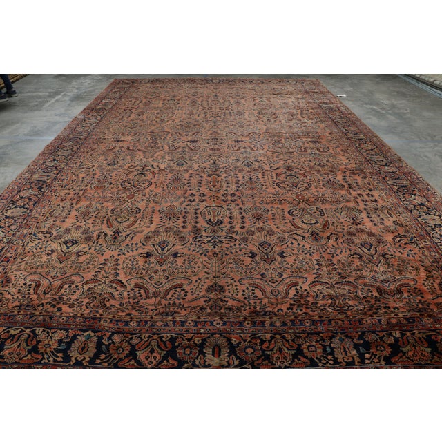 Hand-knotted in wool, this 12x19 antique Persian Sarouk rug originating circa 1920-1930, with intricate floral patterns,...