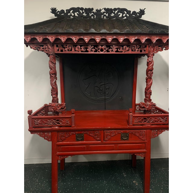 Large Chinese altar shrine cabinet with extensive carved dragon decoration, architectural temple-style roof, pierced...