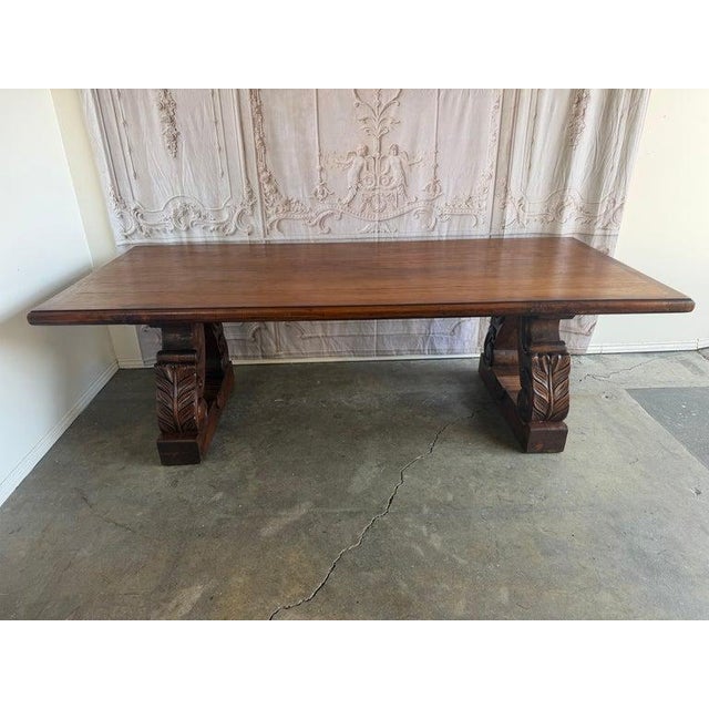 An impressive and richly detailed Spanish Colonial Revival dining table crafted from solid walnut, featuring a substantial...
