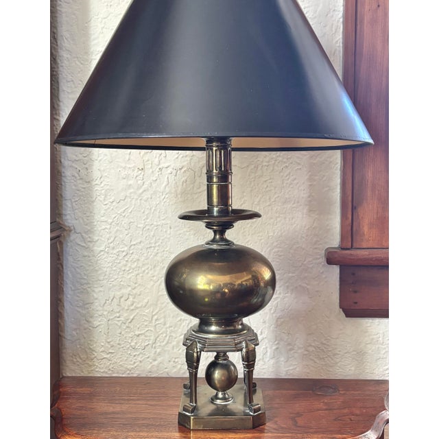 Heavy solid brass table lamp with midcentury modern spheres and lines. Original finial and paired with a black shade....