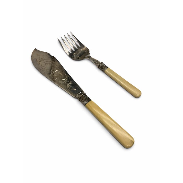 An elegant, beautifully preserved antique Victorian-era fish serving set, featuring a matching serving knife and serving...