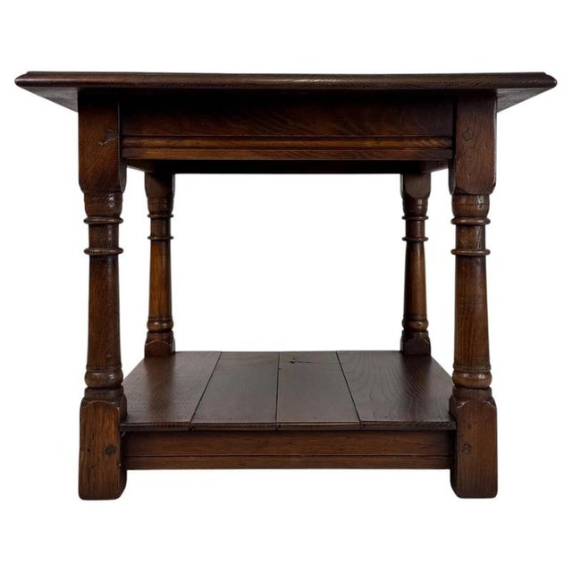 A charming early 20th-century English side table, finely crafted from oak and distinguished by its compact square...