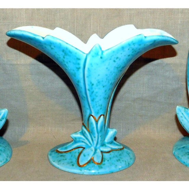 Fabulous three-vase garniture sent with mottled turquoise glaze and gold trim. The matching vases measure 9" x 3.5", the...