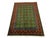 This wool area rug pairs a rich green field with orderly rows of Mori Gul motifs and red geometric accents. Layered...