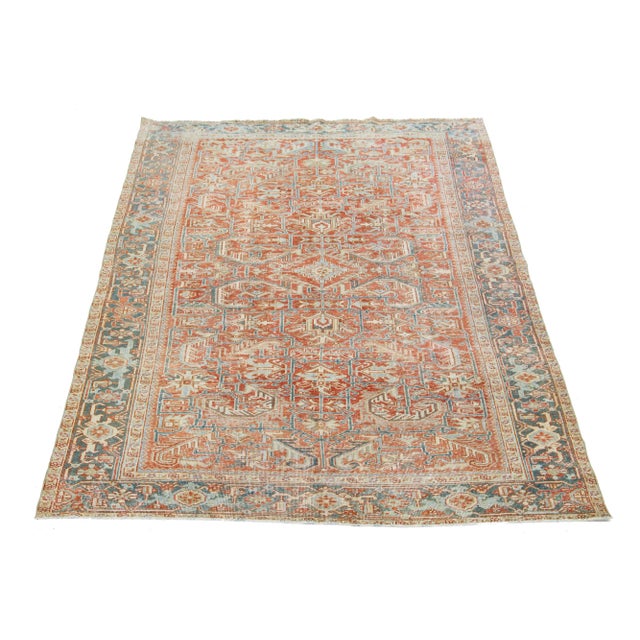 This antique Persian Heriz rug showcases an impressive overall design and is crafted with hand-knotted wool. The rust-...