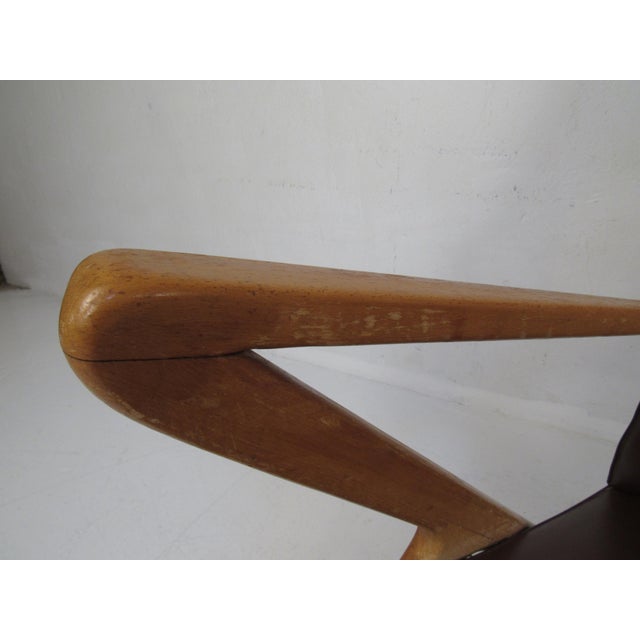 A stunning pair of vintage Italian modern lounge chairs that feature a sculpted teak frame with "Z" shaped sides. The...