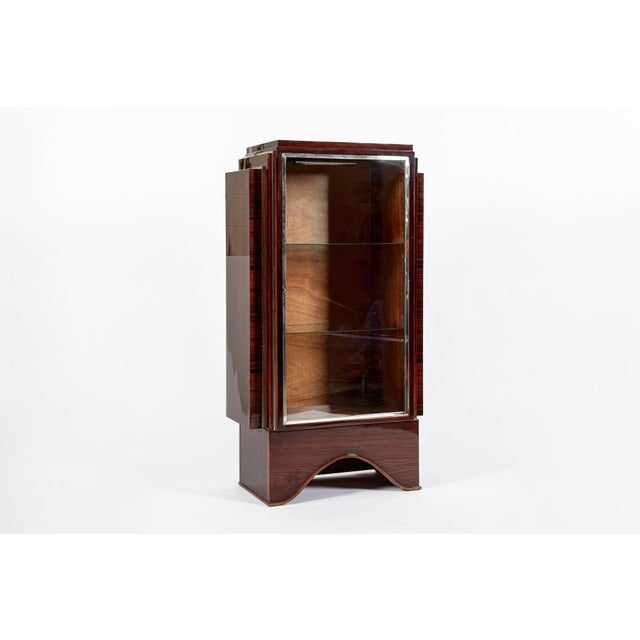 This beautiful antique French Art Deco rosewood and glass vitrine display cabinet was made in France circa 1930. The...