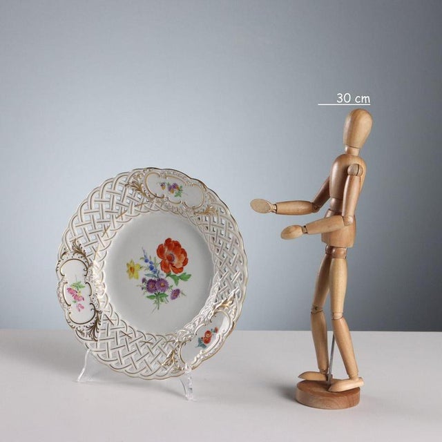 Porcelain plate with polychrome flower bouquet decoration on the hollow and reserves. Perforated rim with pure gold...