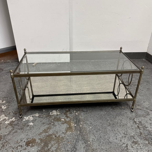 Design Plus Gallery presents a Vintage Hollywood RegencyMetal + Mirrored Glass Cocktail Table. This rectangular cocktail...